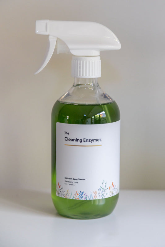 Glass shower door soap scum being cleaned with The Cleaning Enzymes Bathroom Deep Cleaner